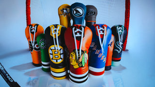 Hometown Brands official NHL headcover collection featuring all US teams. Headcover group featuring Blackhawks, Rangers, Bruins, Stars, Capitals, Kraken, flyers, Penguins, Sharks, and Hurricanes on ice in front of a red and white hockey net.