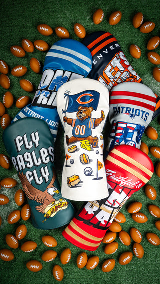 Collection of NFL sports team golf club headcovers on a grassy background with mini footballs.